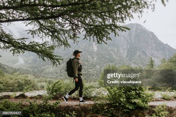 solo female hikerhiking next to mt. hotaka - backpacker stock pictures, royalty-free photos & images