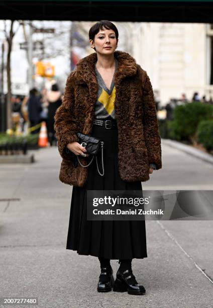 Alyssa Coscarelli is seen wearing a faux brown fur coat, yellow and gray sweater, black skirt and black boots with black Coach purse outside the...