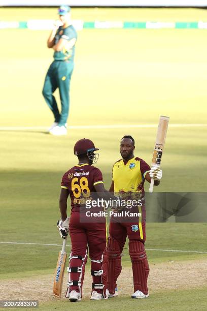 Andre Russell of the West Indies celebrates his half century with Sherfane Rutherford during game three of the Men's T20 International series between...