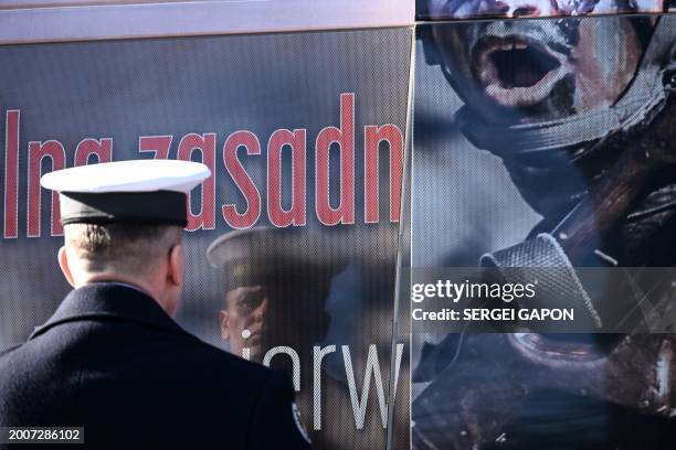Polish honor guard soldier looks at his reflection in a window of a minibus, promoting military service in the Polish army, as he prepares to welcome...