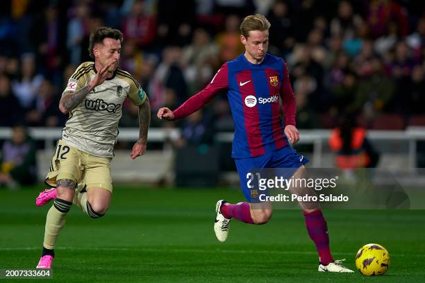 Frenkie De Jong of FC Barcelona competes for the ball with Ricard Sanchez of Granada CF during the LaLiga EA Sports match between FC Barcelona and...