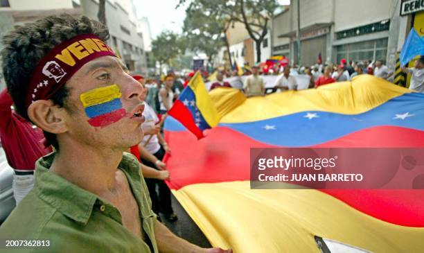 Supporters of Venezuelan President Hugo Chavez paint their faces with the national color 19 December during a march in Caracas. The opposition strike...