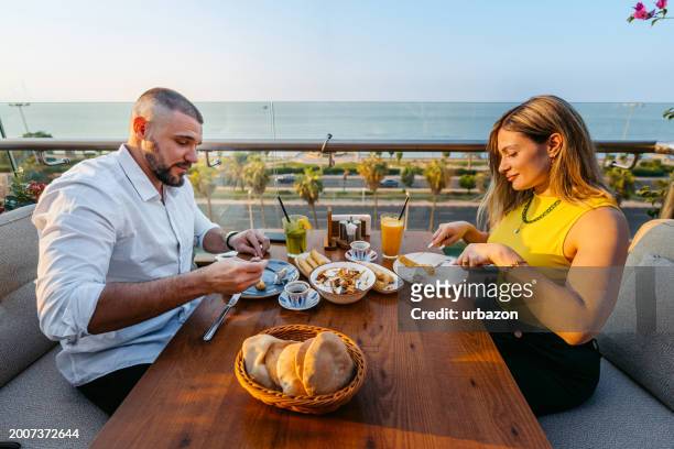 junges paar isst in einem restaurant in kuwait-stadt zu mittag - gcc stock-fotos und bilder