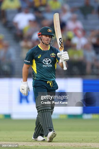 David Warner of Australia raises his bat after reaching his half century during game three of the Men's T20 International series between Australia...
