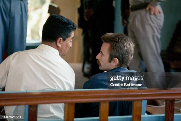 French journalist Régis Debray speaking with his defence lawyer, Paul Novillo, in the courtroom in Camiri, Bolivia, where he is being tried on the...