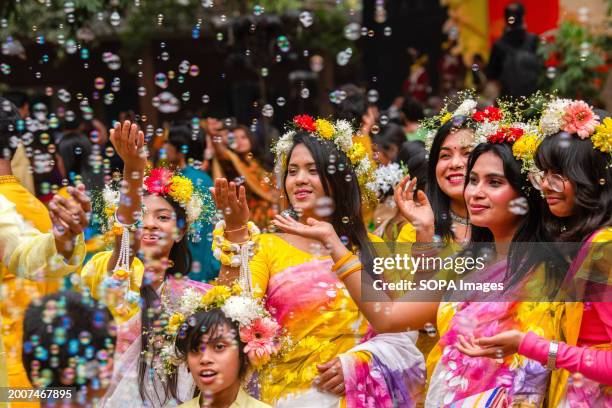 People play with bubbles as they celebrate the spring festival 'Basanta Utsav' at the Faculty of Fine Arts of the University of Dhaka in Bangladesh....