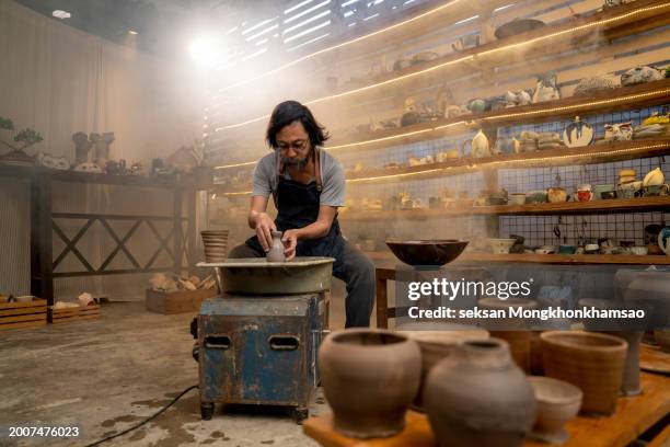 bearded old craftsman in pottery workshop - sculpteur photos et images de collection