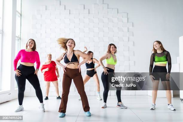 group of women dancing zumba in dancing room - zumba stockfoto's en -beelden