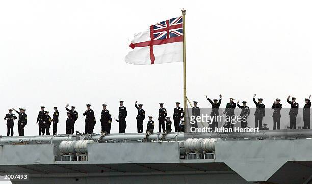 Sailors wave from the aircraft carrier HMS Ark Royal as she returns to her base 126 days after she set sail May 17, 2003 in Portsmouth, England. The...