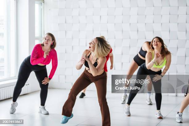 group of women dancing zumba in dancing room - zumba stock pictures, royalty-free photos & images