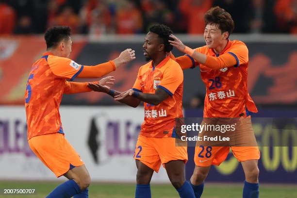 Fei Nanduo of Shandong Taishan celebrates with teammates Gao Zhunyi and Zheng Zheng after scoring the team's first goal during the AFC Champions...