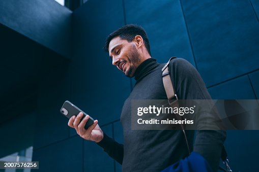 Portrait of a Handsome Man Waiting by the Office Building and Reading a Text Message Portrait of a Handsome Man Waiting by the Office Building and Reading a Text Message