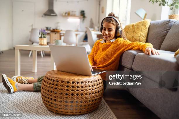 young woman using laptop, while having headphones on - zoom stock pictures, royalty-free photos & images