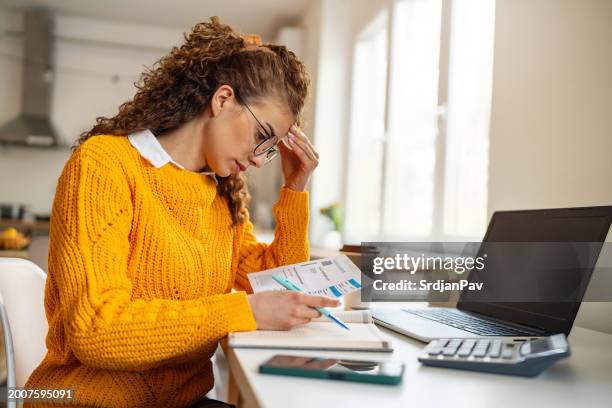 worried young caucasian woman organizing home finances - stress test stockfoto's en -beelden