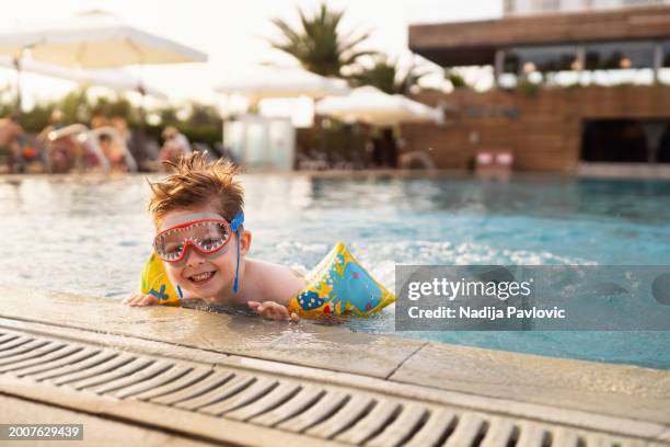 little boy enjoying a day at the swimming pool - arm band stock pictures, royalty-free photos & images