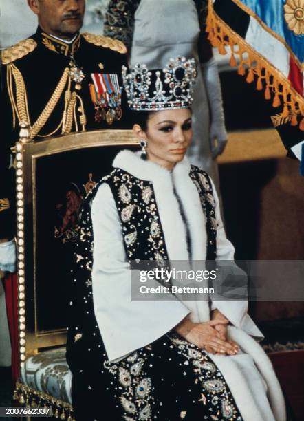 Farah Pahlavi, Empress of Iran, sitting on a throne chair during the coronation ceremony of herself and her husband, Mohammad Reza Pahlavi, the Shah...