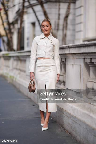 Olivia Ponton wears golden earrings, a white cropped leather jacket with buttons and long sleeves, a brown padded / quilted leather monogram logo...