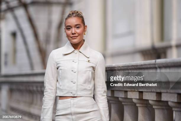 Olivia Ponton wears golden earrings, a white cropped leather jacket with buttons and long sleeves, outside Coach, during New York Fashion Week, on...