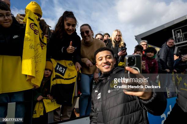 Jadon Sancho of Borussia Dortmund takes a selfie with the fans after a training session of Borussia Dortmund on February 13, 2024 in Dortmund,...