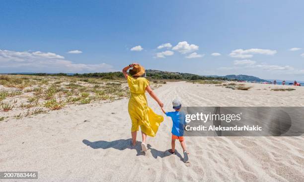 mother and son are walking down the beach - mothers day beach fotografías e imágenes de stock