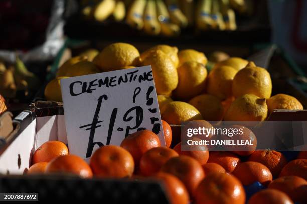 Price tag is seen on clementines in a street market in Portobello road, in west London on February 16, 2024. Britain is in recession, official data...