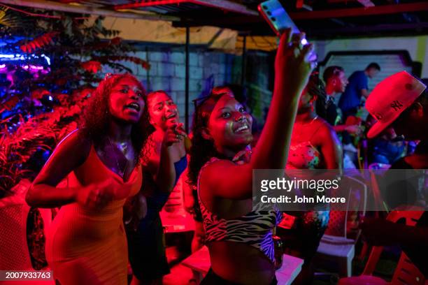 Revelers dance while photographing themselves during Carnival celebrations on February 12, 2024 in Esmeraldas, Ecuador. Violent crime has dropped...
