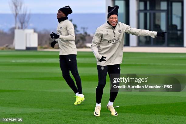 Kylian Mbappe and Nuno Mendes of Paris Saint-Germain react during a training session prior the UEFA Champions League 2023/24 round of 16 first leg...