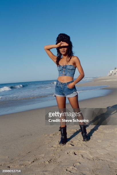 Portrait of American model and actress Robin Givens as she poses on a beach, Malibu, California, 1992.