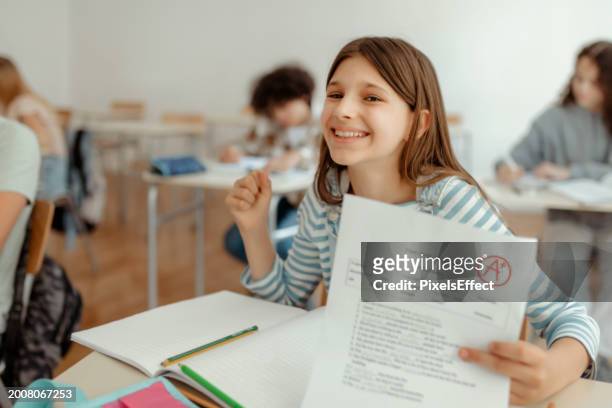 portrait of smiling schoolgirl with perfect grade - child report card stock pictures, royalty-free photos & images