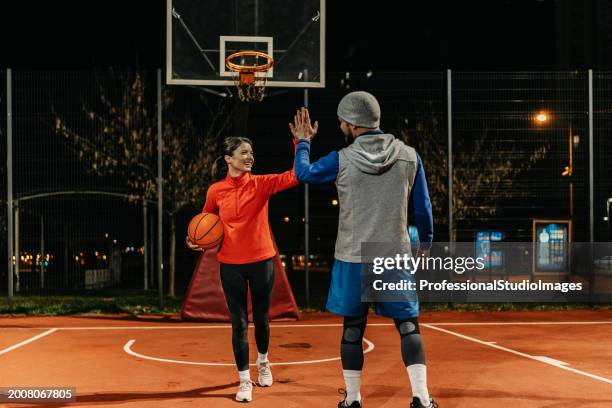 geste de partenariat nocturne - compétition de basket ball photos et images de collection