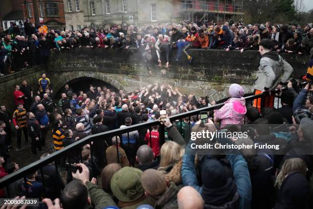 Players from the Up'ards and the Down'ards wade through the River Henmore as they battle for the ball during the annual 'no rules' Royal Shrovetide...