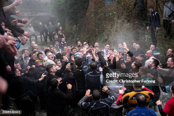 Players from the Up'ards and the Down'ards wade through the River Henmore as they battle for the ball during the annual 'no rules' Royal Shrovetide...