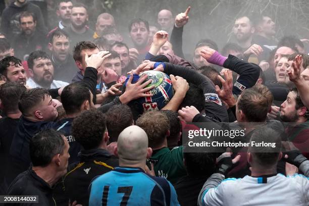 Players from the Up'ards and the Down'ards wade through the River Henmore as they battle for the ball during the annual 'no rules' Royal Shrovetide...