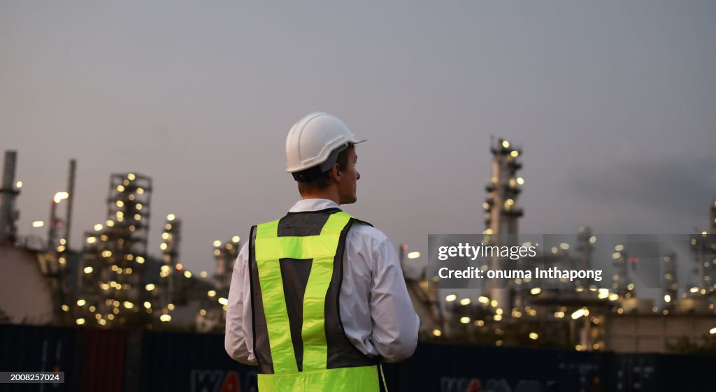 L’ingénieur chimiste travaille tard le soir à la raffinerie de pétrole d’une zone industrielle. Génie chimique, production de carburant et d’énergie, concept d’industrie d’usine pétrochimique