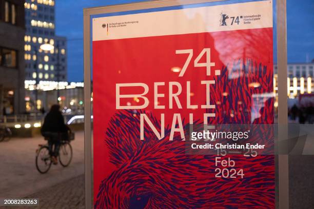 Woman on a bicycle rides past posters for the 2024 Berlinale Berlin International Film Festival ahead of the 74th Berlinale International Film...