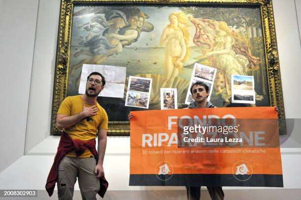 Protesters from the action group Ultima Generazione stick a sign and photographs of floods on the glass covering Sandro Botticelli's La nascita di...