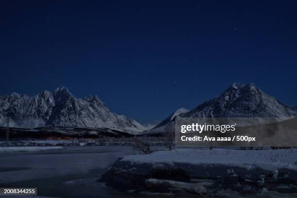 scenic view of snowcapped mountains against sky at night,norway - ava stock pictures, royalty-free photos & images