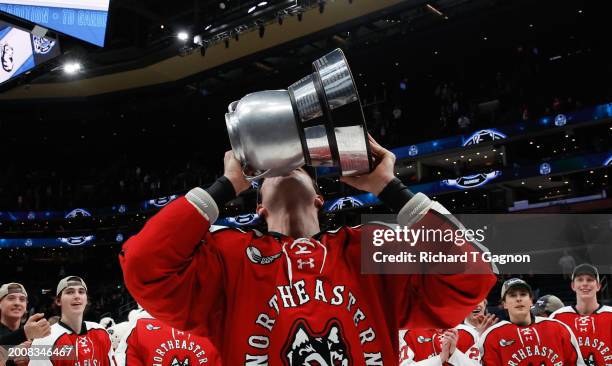 Pito Walton of the Northeastern Huskies celebrates with the Beanpot trophy after a victory against the Boston University Terriers during NCAA mens...