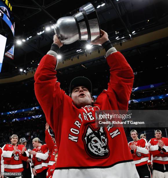 Pito Walton of the Northeastern Huskies celebrates with the Beanpot trophy after a victory against the Boston University Terriers during NCAA mens...