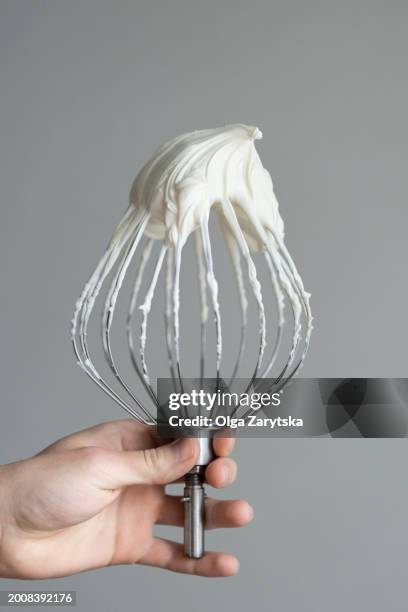 chef hand holding whisk with whipped ganache. - fouet manuel photos et images de collection