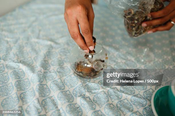 cropped hands of woman holding container on table,belo horizonte,state of minas gerais,brazil - woman frog hand stockfoto's en -beelden