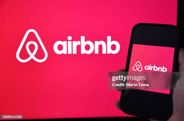 In this photo illustration, the Airbnb logo is displayed on a computer monitor and cell phone on February 13, 2024 in Los Angeles, California. Airbnb...