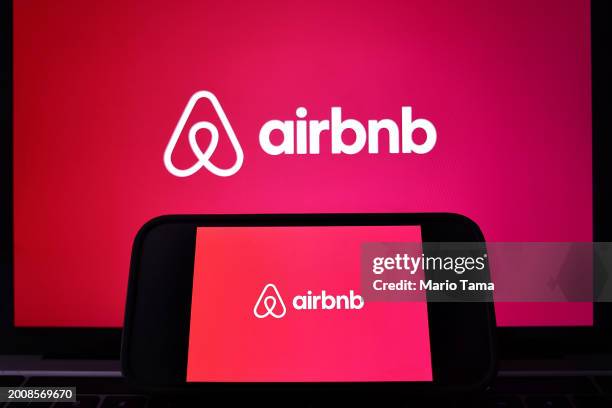 In this photo illustration, the Airbnb logo is displayed on a computer monitor and cell phone on February 13, 2024 in Los Angeles, California. Airbnb...