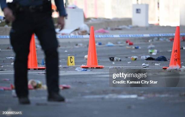 Police officers investigate the scene of a shooting where at least one person was killed and more than 20 others were injured after the Kansas City...