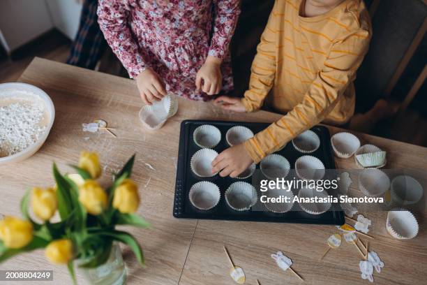 children's hands preparing festive cupcakes - cupcake holder stock pictures, royalty-free photos & images