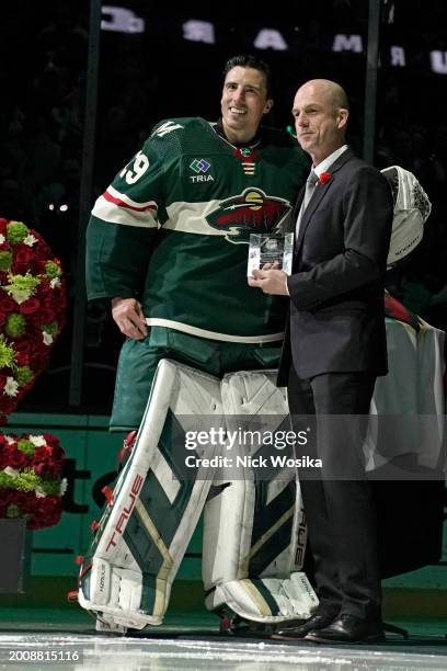 Executive Kay Whitmore presents Marc-Andre Fleury of the Minnesota Wild a trophy in recognition of his 1000 career games before a game against the...