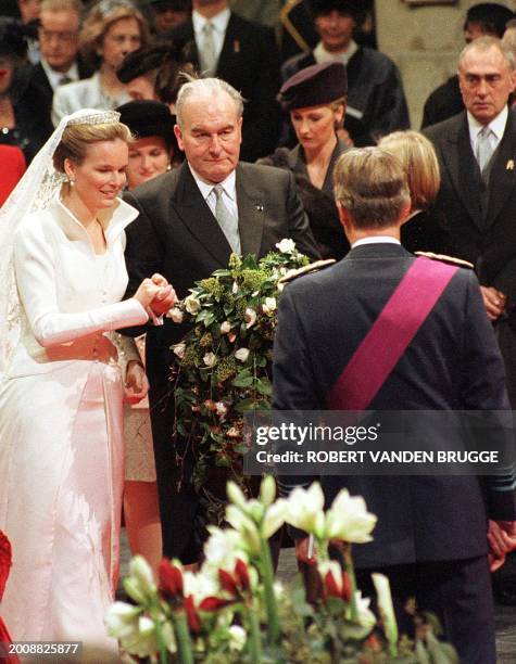 Crown Prince Philippe of Belgium watches Princess Mathilde accompanied by her father Count Patrick d'Udekem d'Acoz arriving in Saint Michel cathedral...