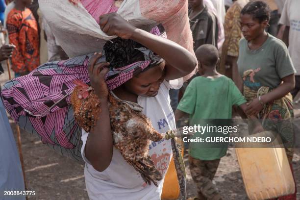 Displaced people go about their daily business west of the town of Goma, eastern Democratic Republic of Congo, on February 16, 2024. The conflict...