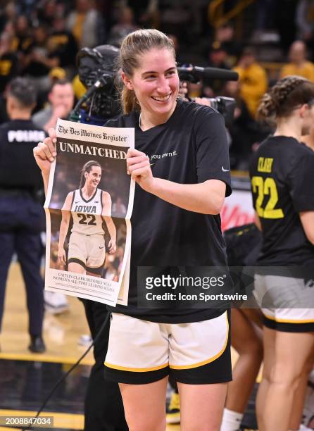 Iowa guard Kate Martin holds up the front page of the "Des Moines Register" after winning a women's college basketball game between the Michigan...