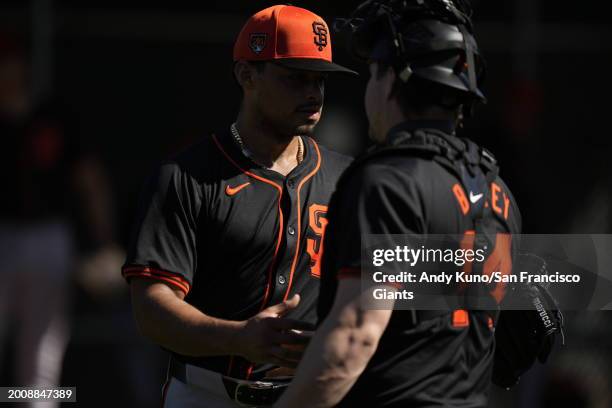 Jordan Hicks and Patrick Bailey of the San Francisco Giants shake hands after a bullpen session during the workout at Scottsdale Stadium on February...